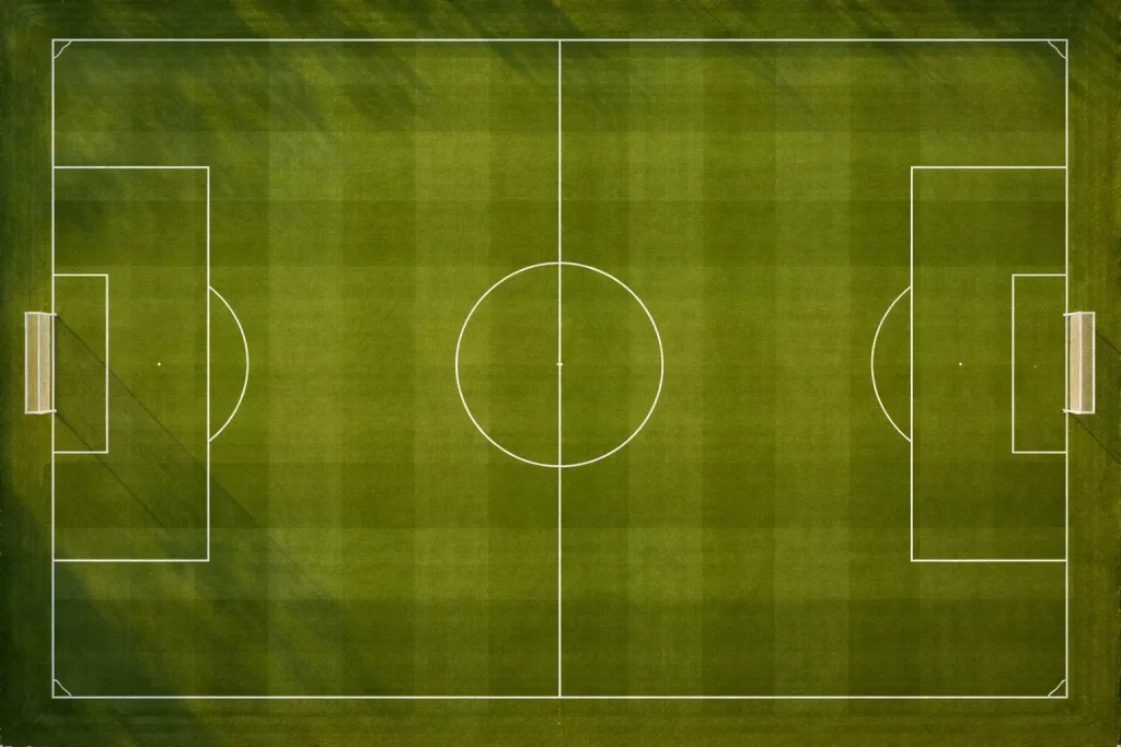 Campo da calcio visto dall'alto con linee bianche sul prato verde curato