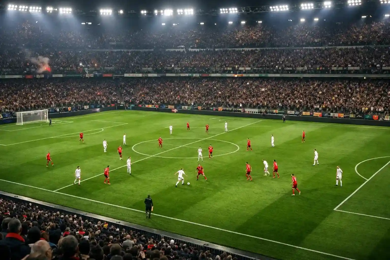 Partita di calcio in corso su campo illuminato vista dalle tribune